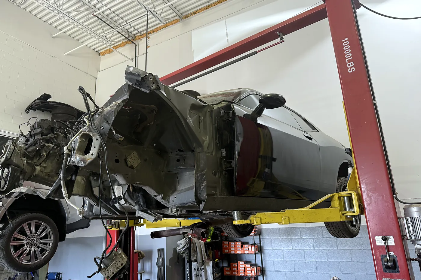 Front clip cut away from a unibody on the hoist during structural collision repair at Sultan Motors