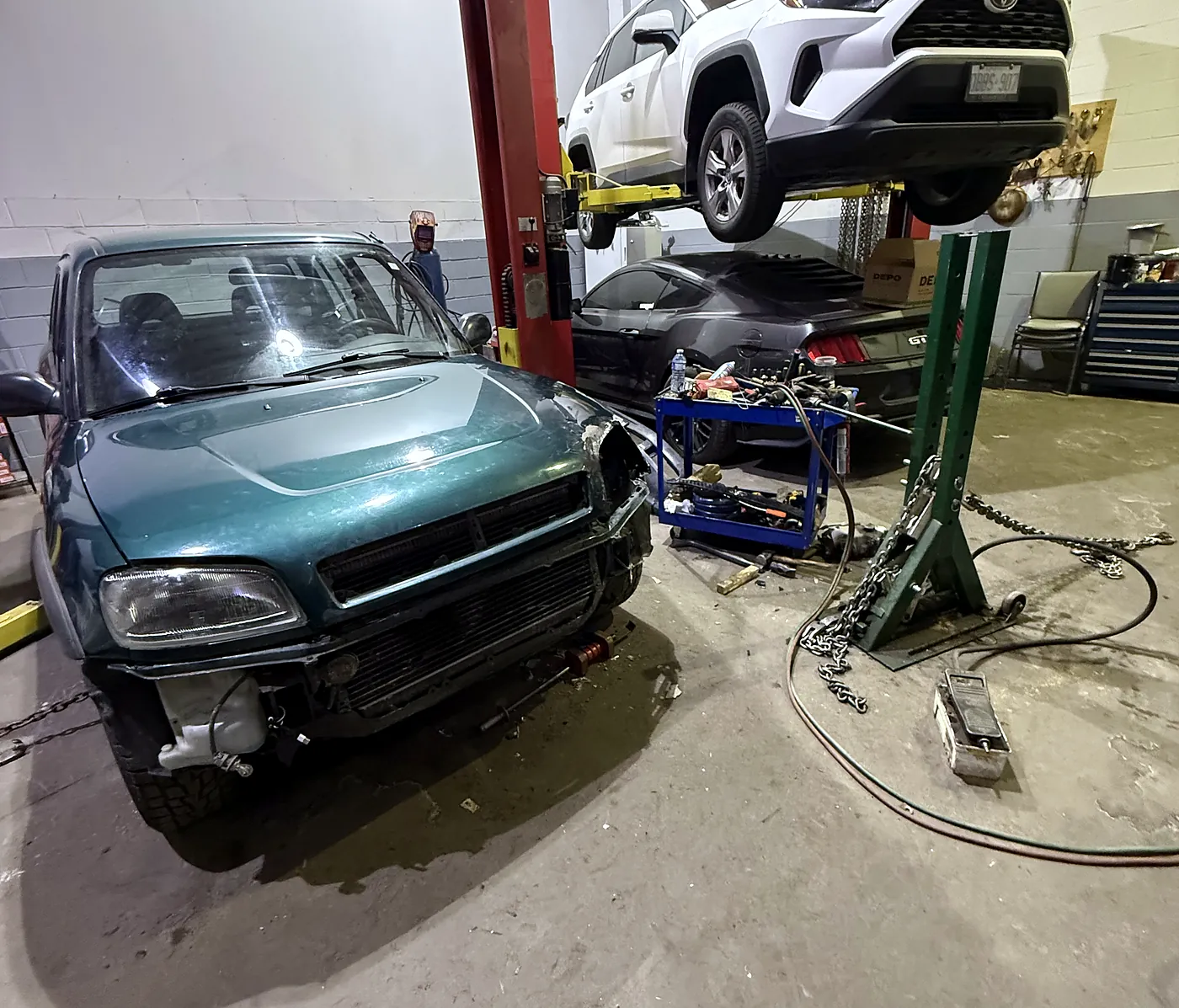 Sultan Motors service bay with a Toyota RAV4 raised on a two-post hoist for repair work in Brampton