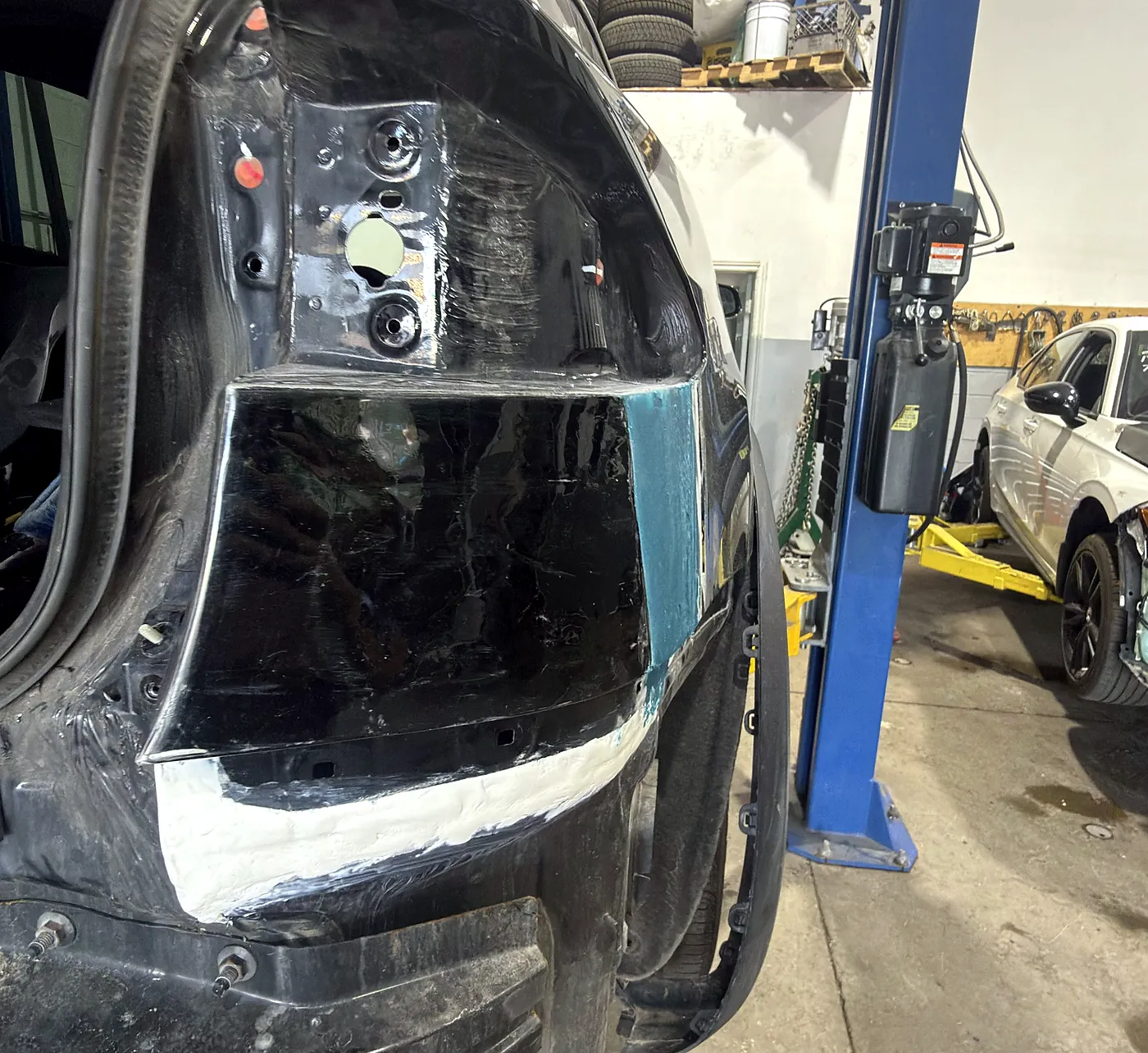 Guide coat sanding across filler on an SUV rear quarter panel during body repair at Sultan Motors