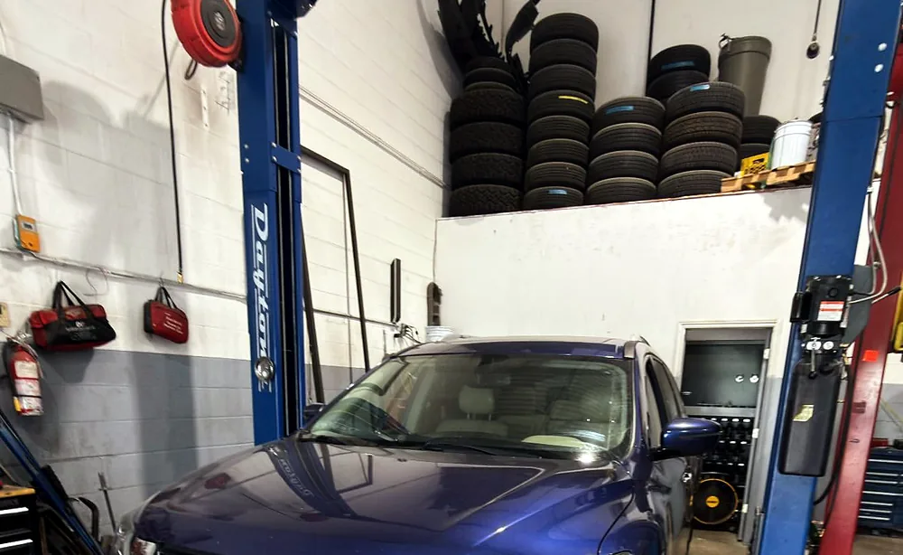 Nissan Pathfinder raised on a two-post hoist for front and rear rotor and pad replacement
