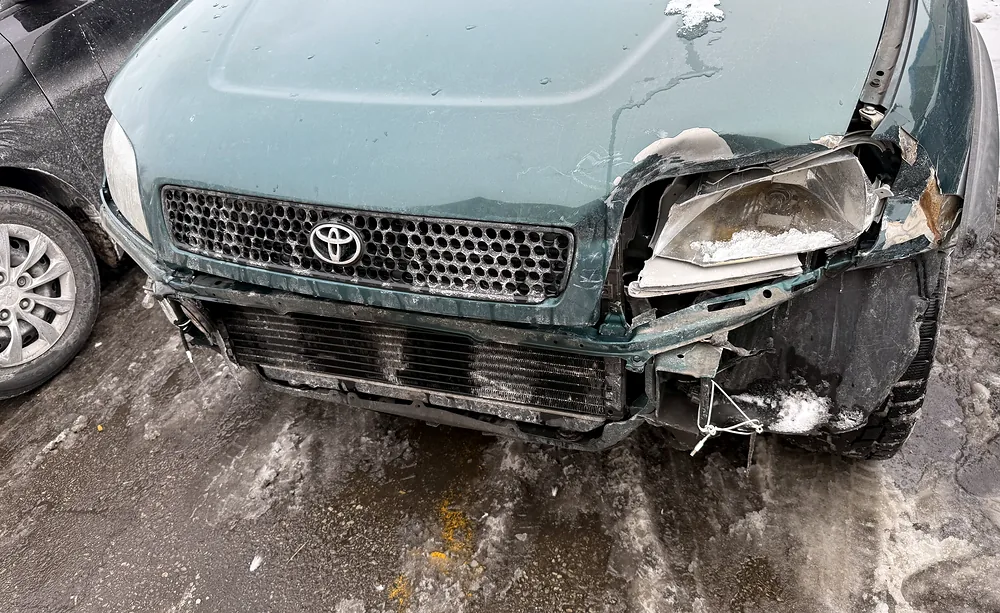 Shattered headlight and destroyed bumper corner on a collision-damaged Toyota RAV4 at Sultan Motors