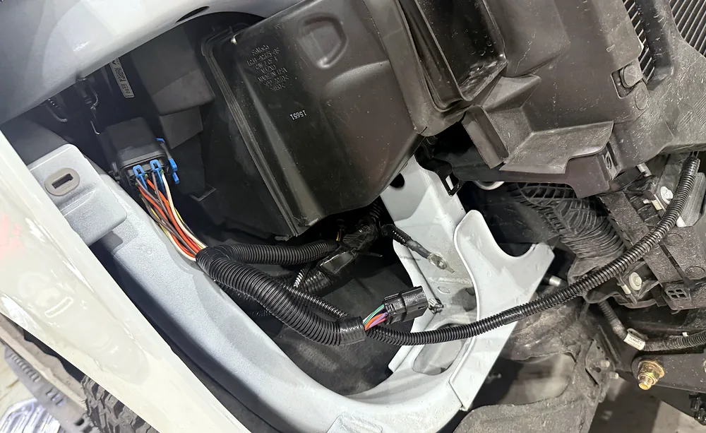 Relay and fuse box with wiring harness connectors exposed under the hood during electrical fault testing at Sultan Motors