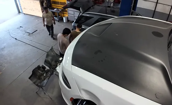 Sultan Motors technicians reviewing a job at the tool chest beside a vehicle with its hood raised in the Brampton bay