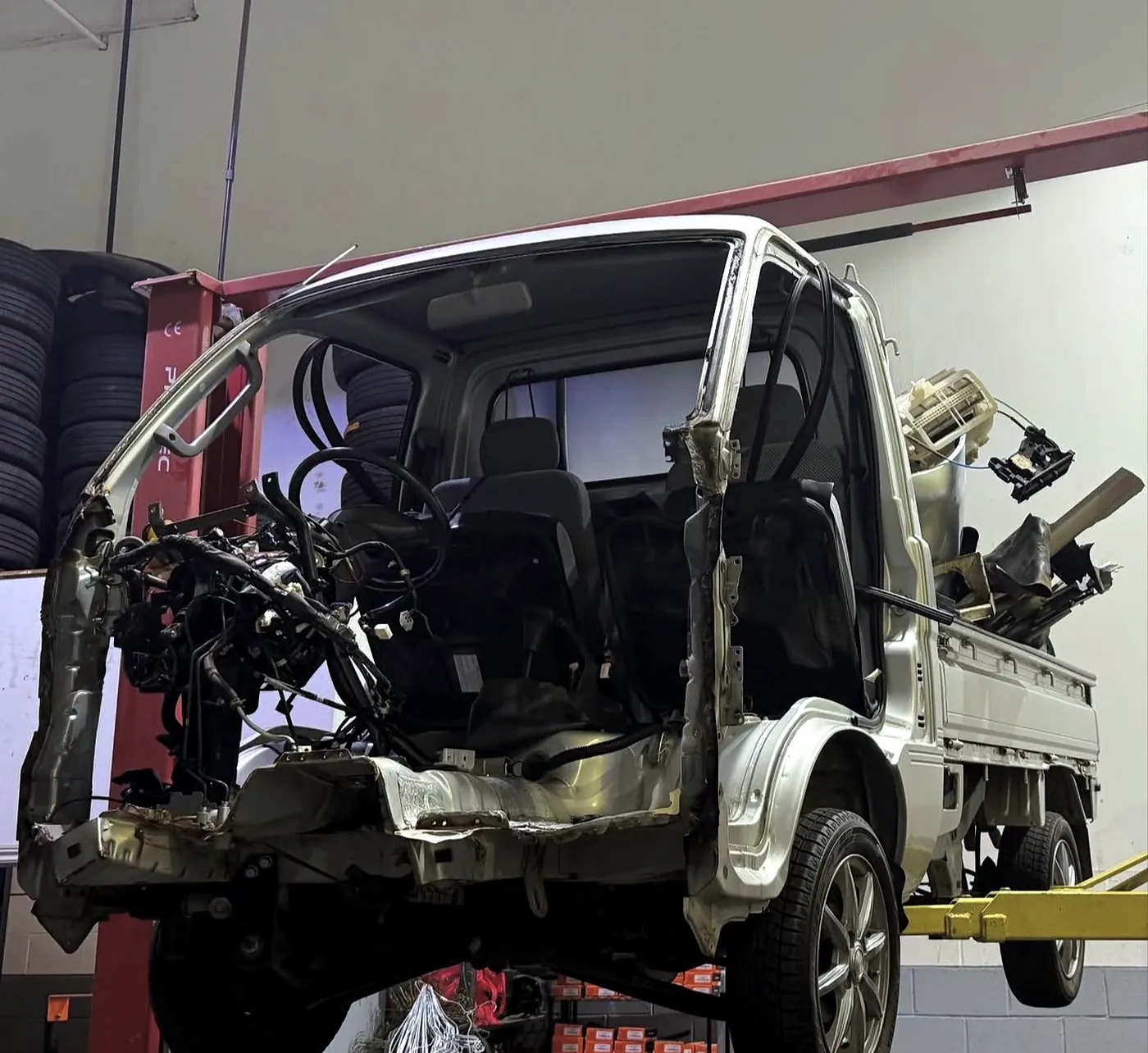 Cab-over flatbed truck with the dashboard and trim removed to access the wiring harness at Sultan Motors
