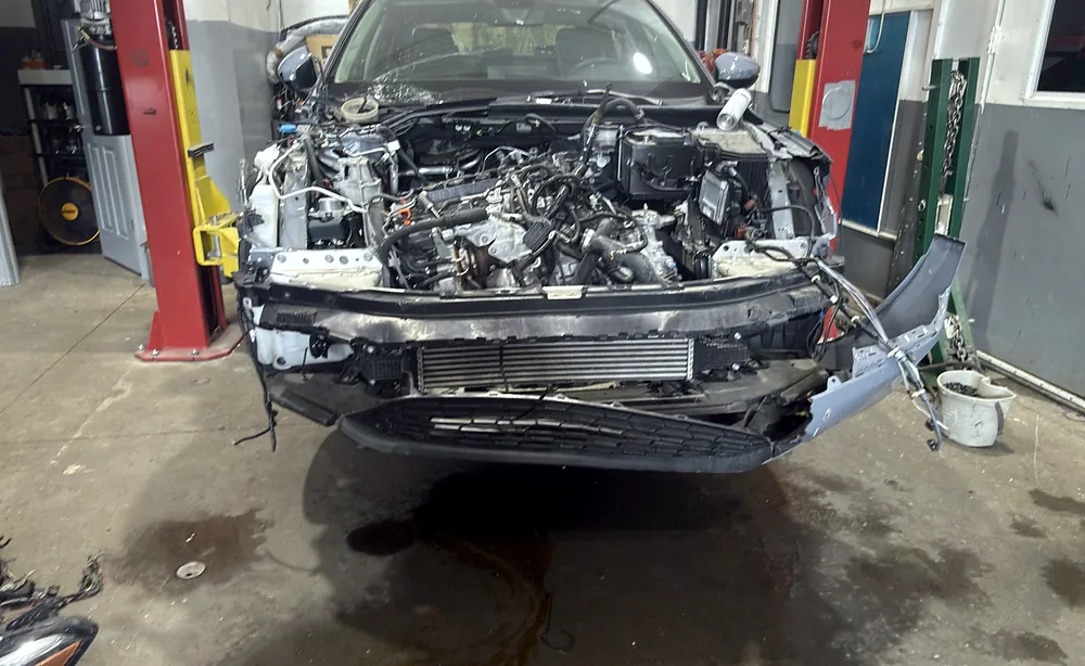 Front fascia removed to expose the radiator, air conditioning condenser and cooling stack during engine work