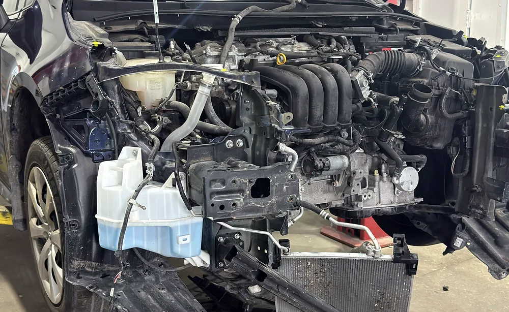 Front clip fully disassembled with the engine bay open during a major mechanical repair at Sultan Motors