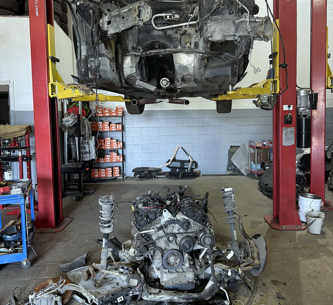 Complete engine and front subframe removed onto a shop dolly during an engine repair at Sultan Motors