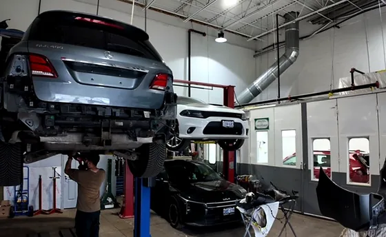 Technician working beneath a crossover raised on a two-post hoist at Sultan Motors