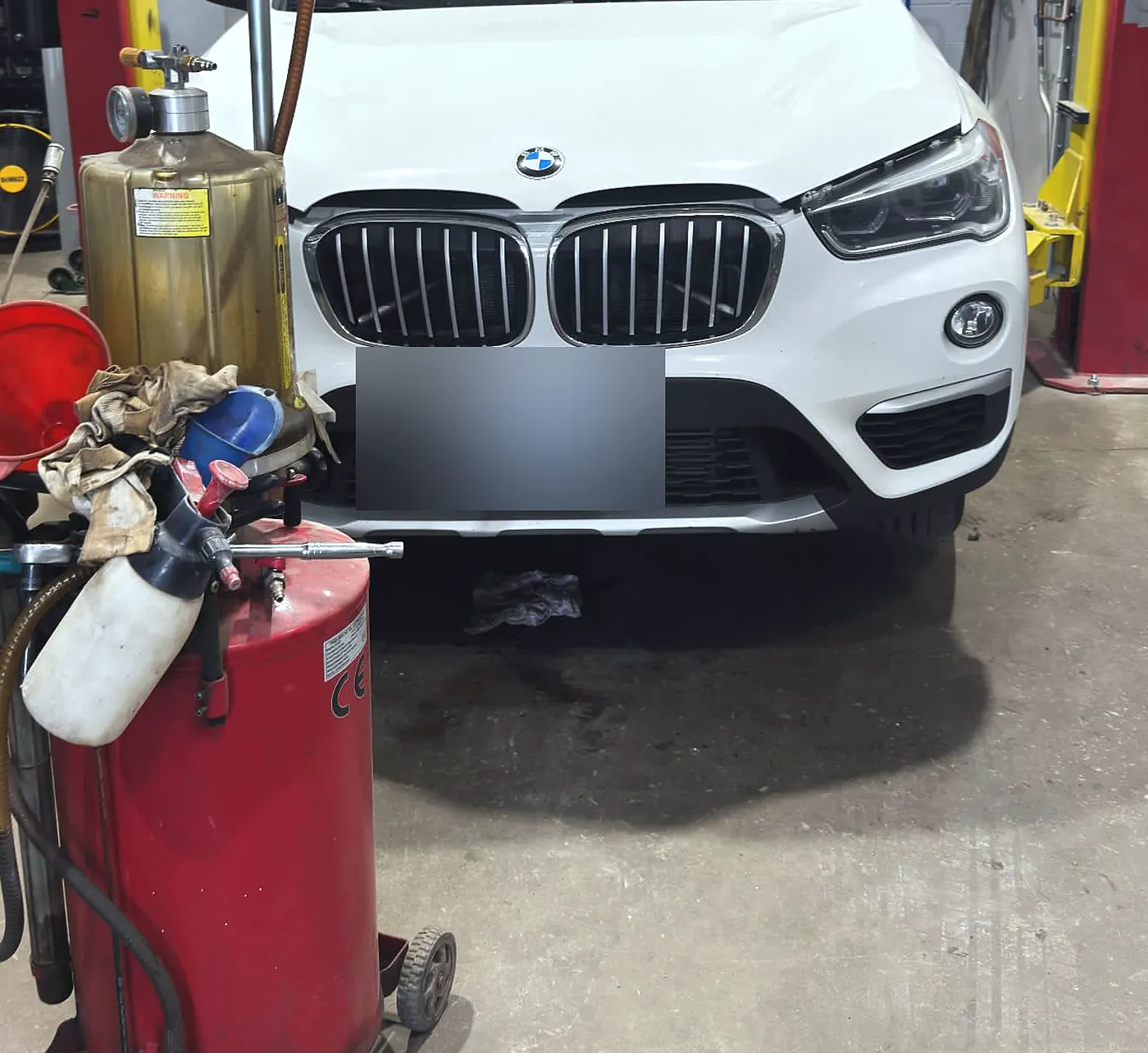 BMW X1 on the hoist at Sultan Motors during an oil change, cooling system flush and transmission fluid service