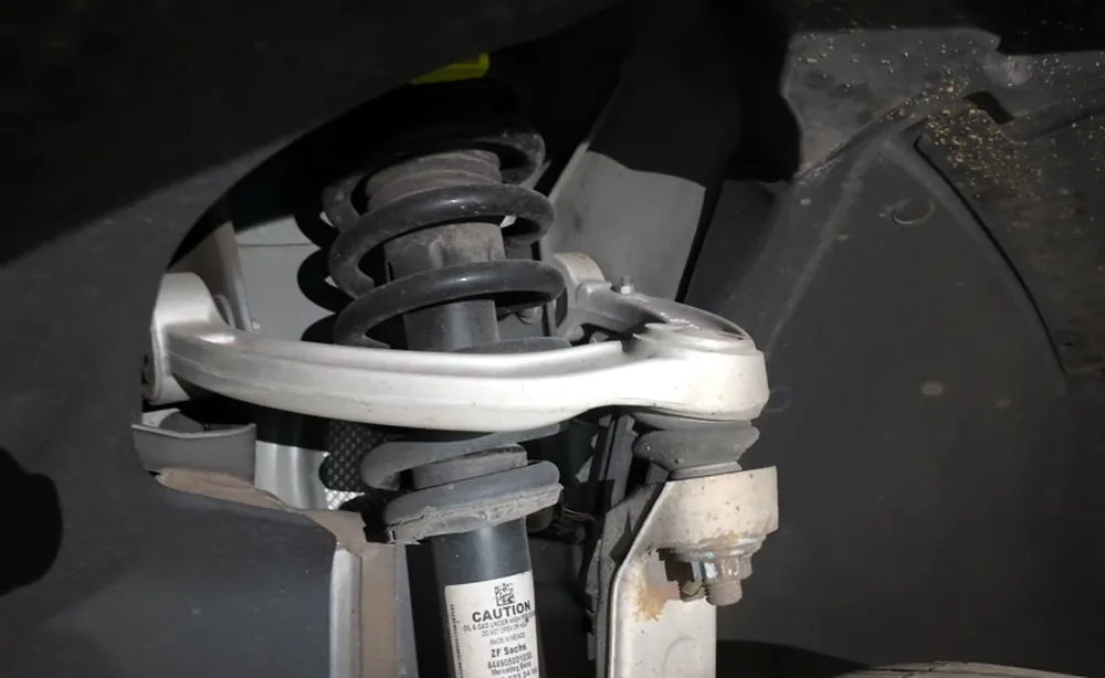Macro view of a front strut and coil spring assembly inside the wheel well at Sultan Motors